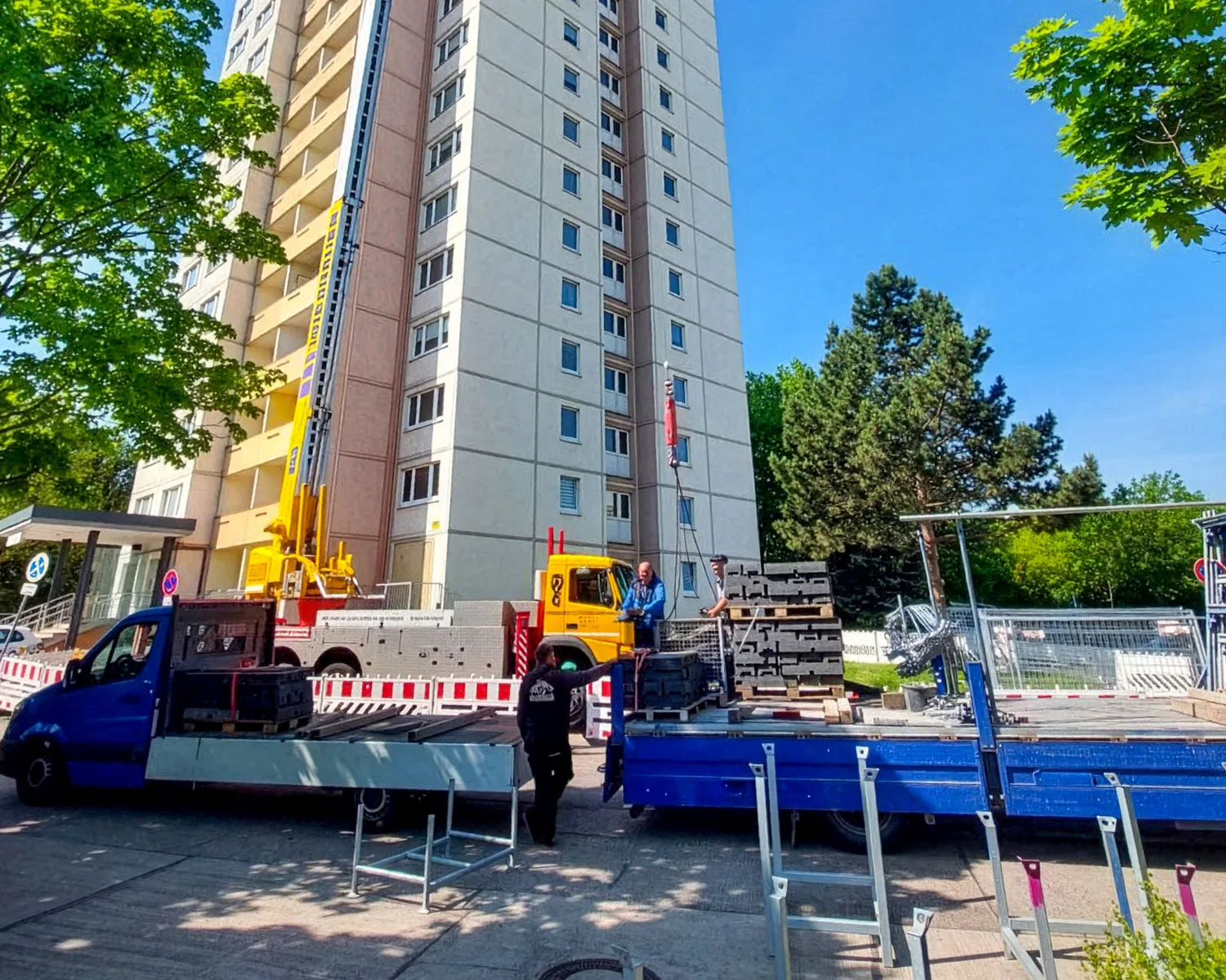 Baustelle mit Kran vor einem Wohnhochhaus