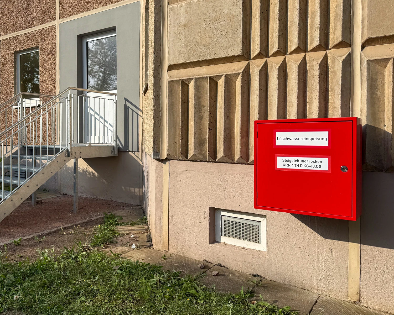 Roter Kasten zur Löschwassereinspeisung an einer Hausfassade