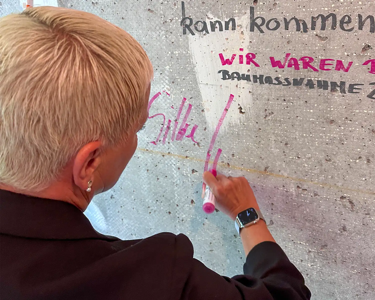 Frau schreibt eine Botschaft an eine Betonwand